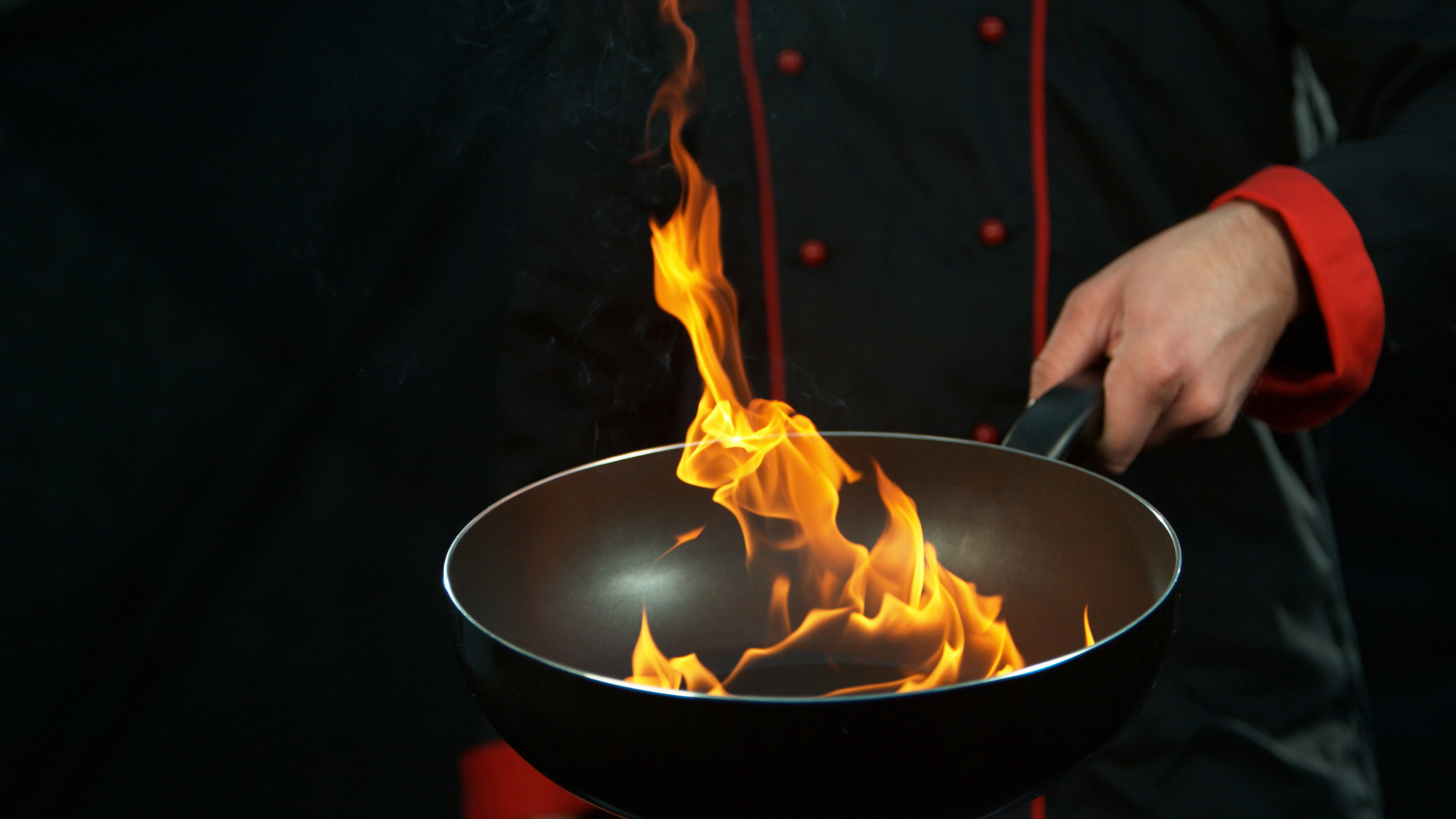 Chef Holding Empty Wok Pan with Flames